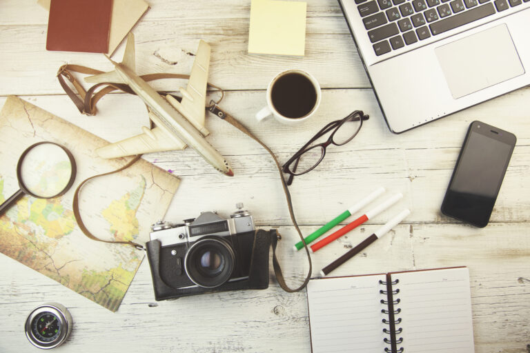 How to Write Website Copy That Sells Your Experience (Without Sounding Salesy) Writing tourism website copy with travel map, laptop, and camera on desk